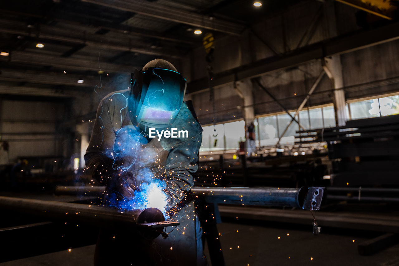 The welder works in the workshop. the moment of welding of metal structures.