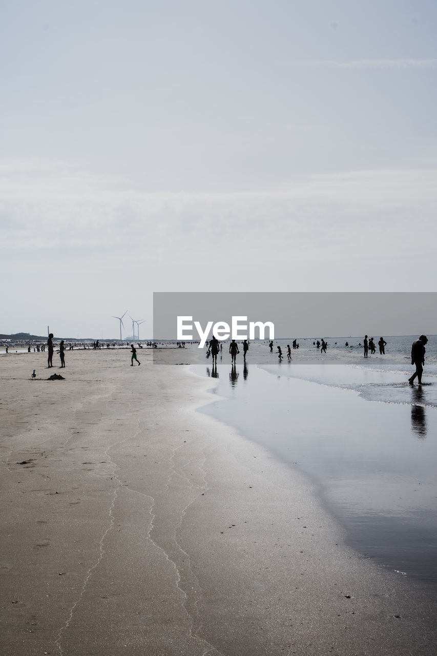 People on beach against sky