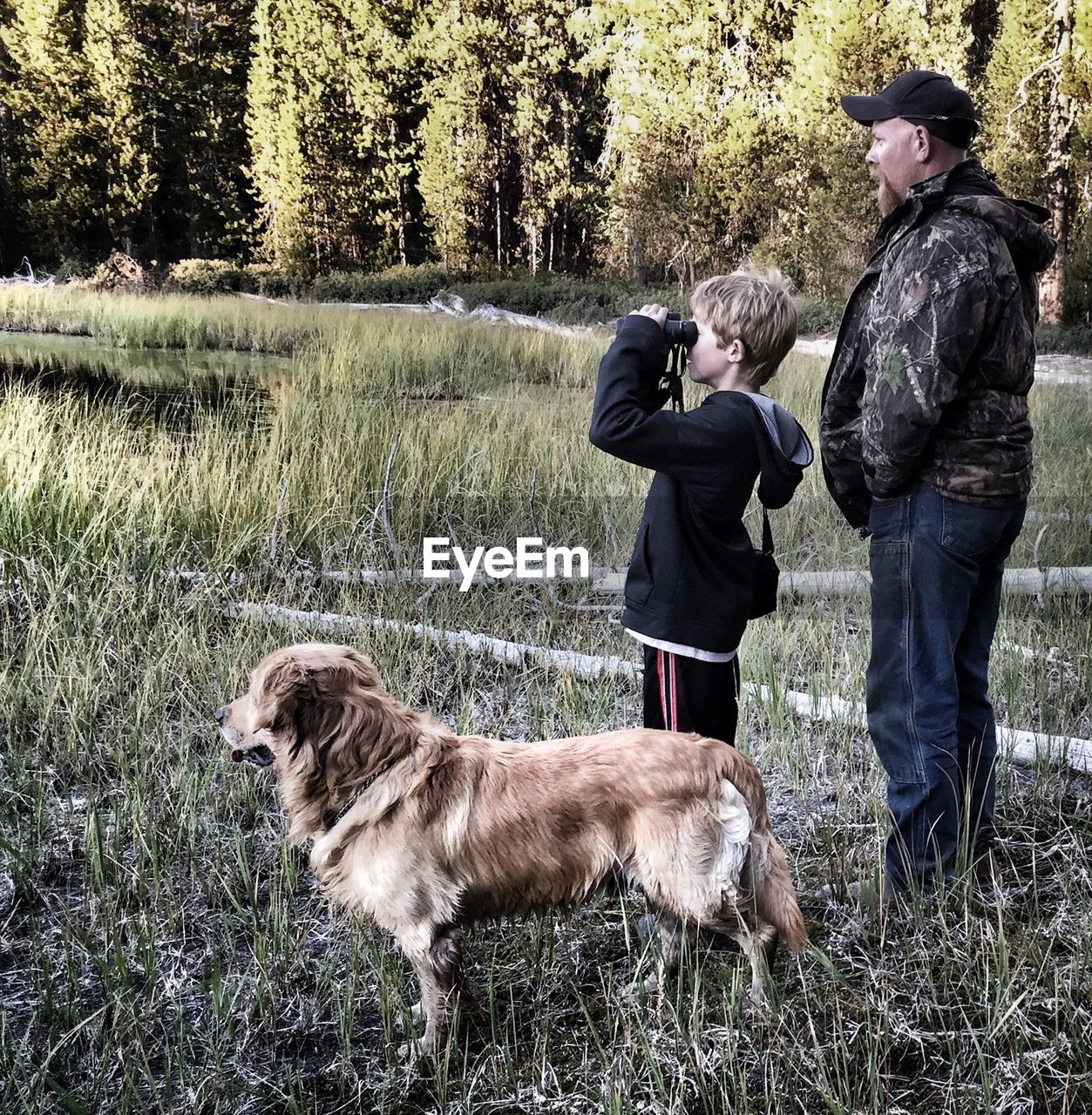 Father and son on a field with dog