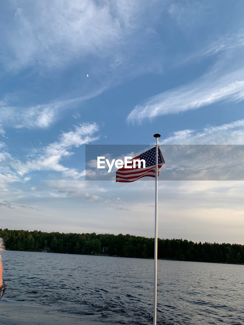 RED FLAG ON RIVER AGAINST SKY