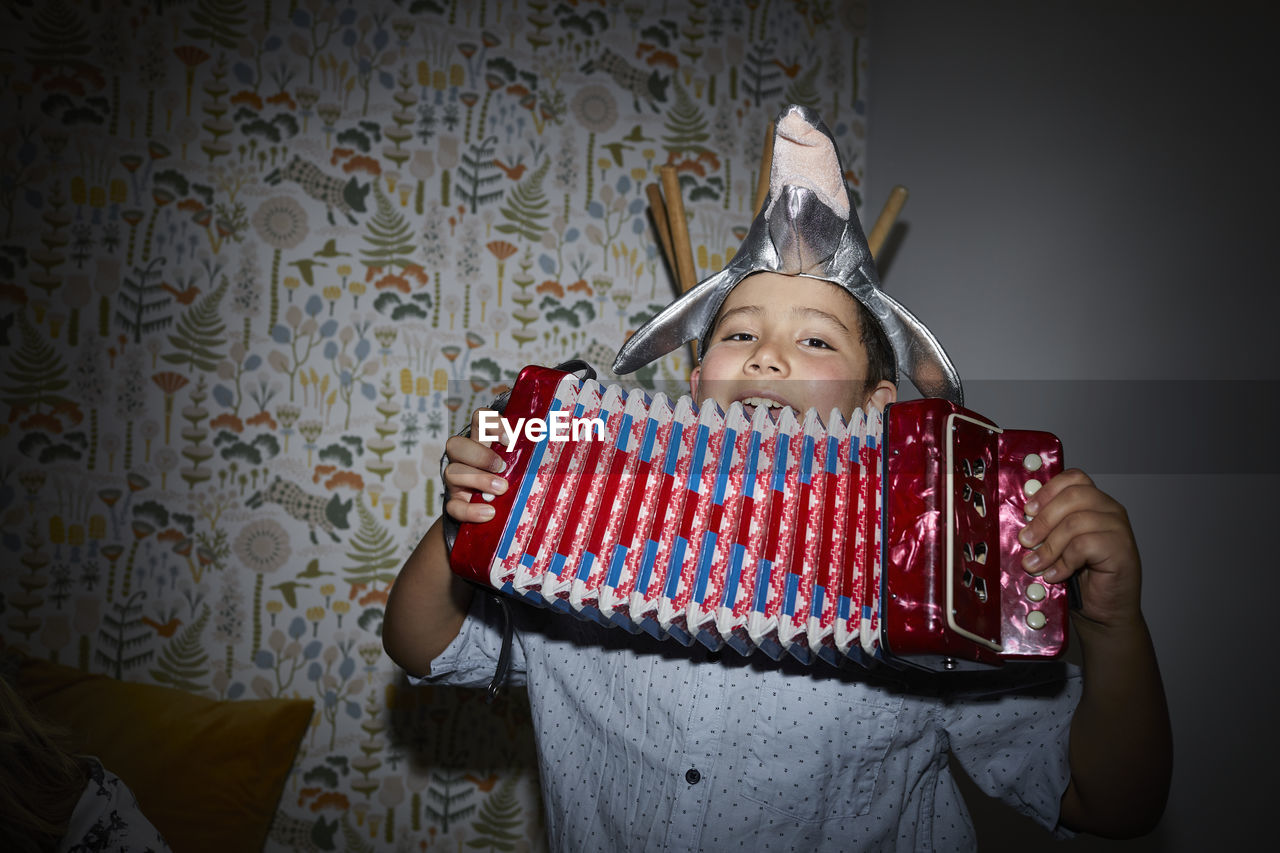 Smiling boy playing accordion