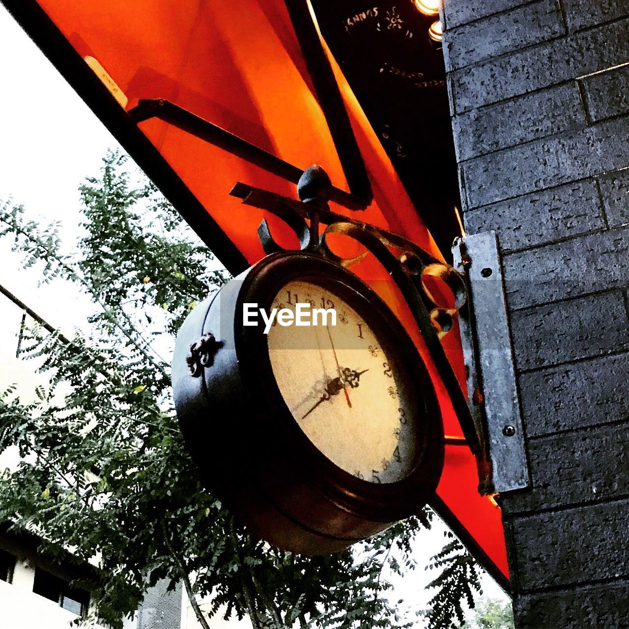 LOW ANGLE VIEW OF CLOCK AGAINST BLURRED BACKGROUND