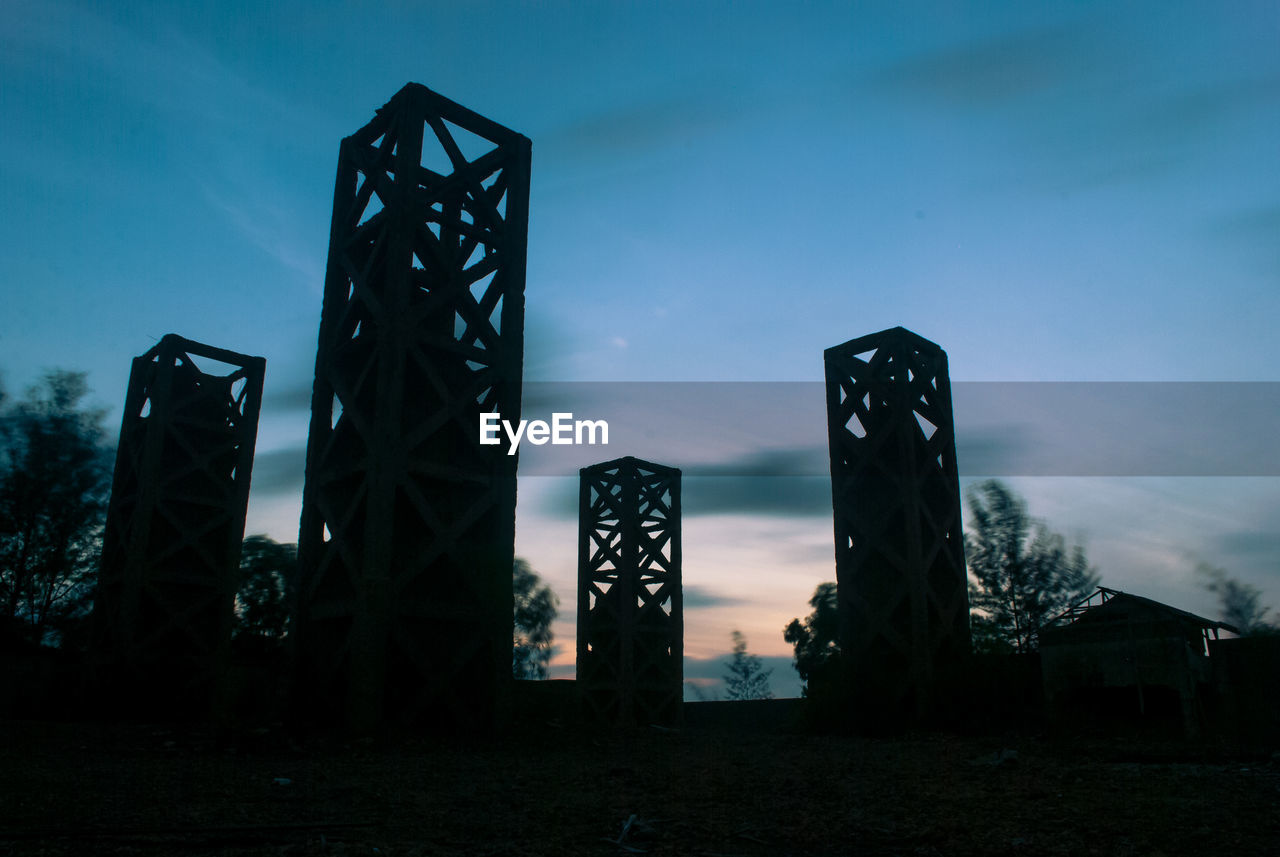 Low angle view of silhouette built structure against blue sky