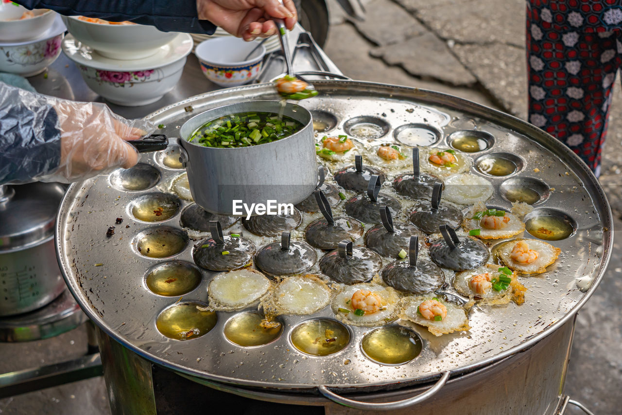 Woman making vietnamese tiny sizzled pancake- banh khot vung tau