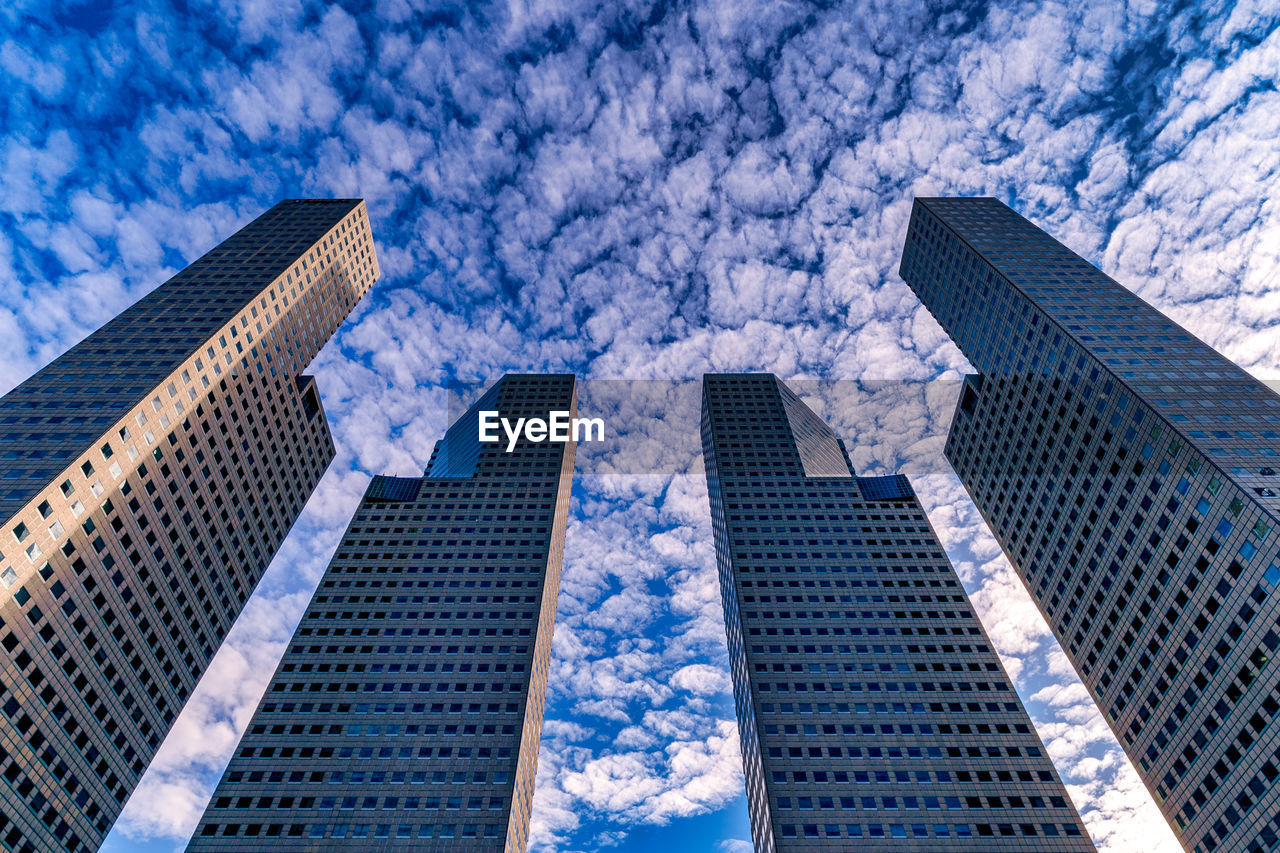 Low angle view of modern buildings against blue sky