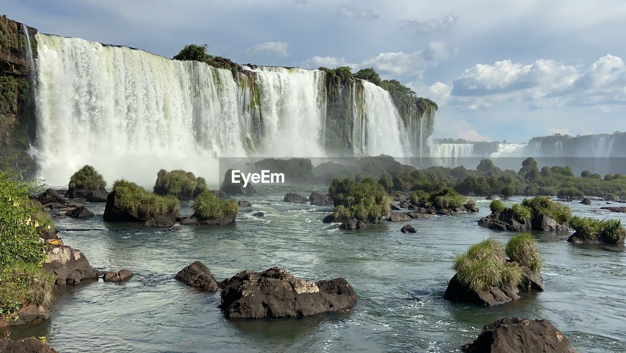 Scenic view of waterfall against sky