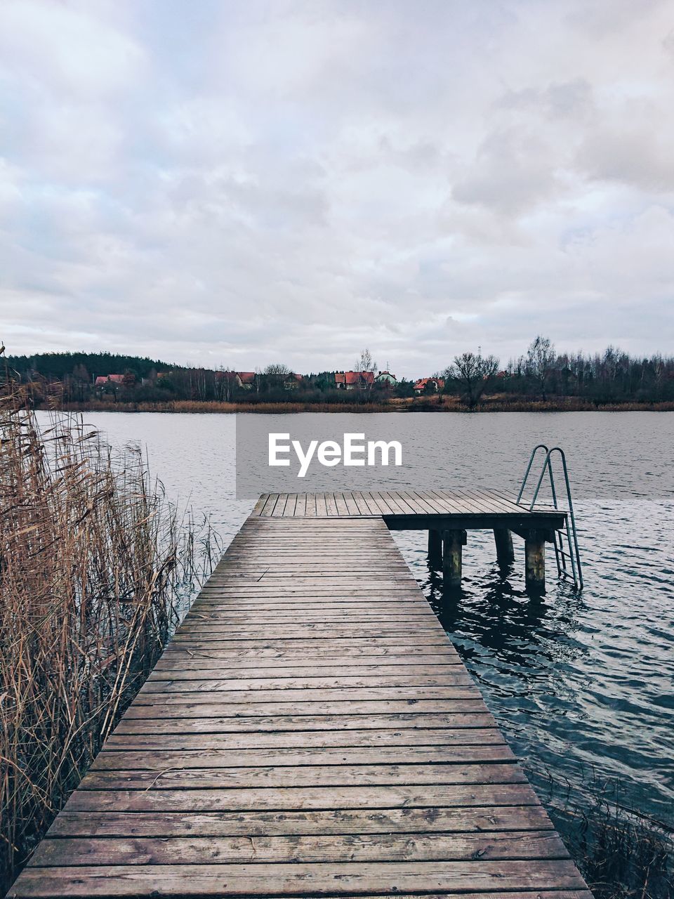 Wooden pier over lake against sky