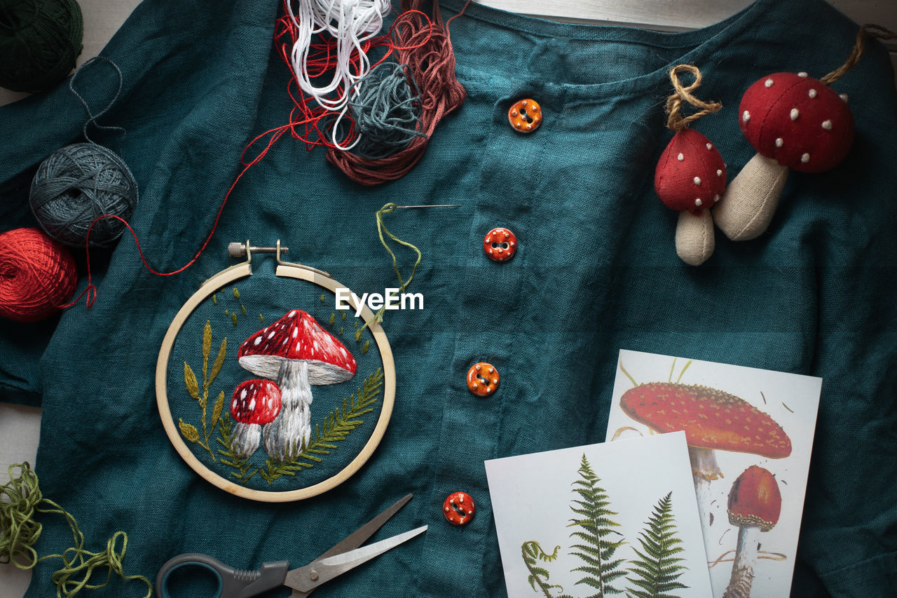 Flat lay with handmade fly agaric mushroom embroidery on dress