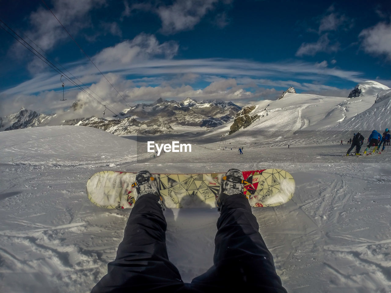 Low section of person snowboarding on snowcapped mountain