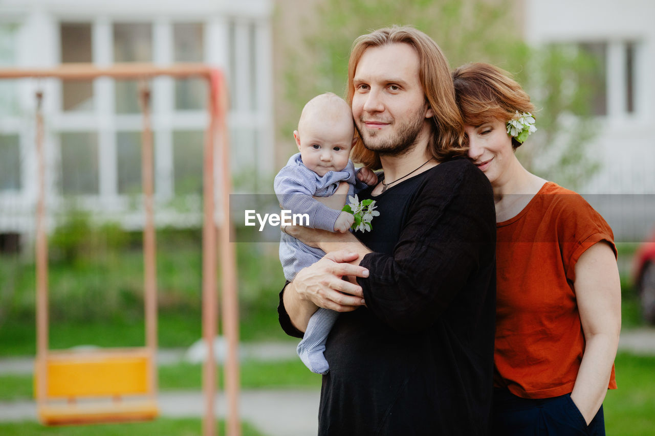 Happy family with baby on playground outdoors