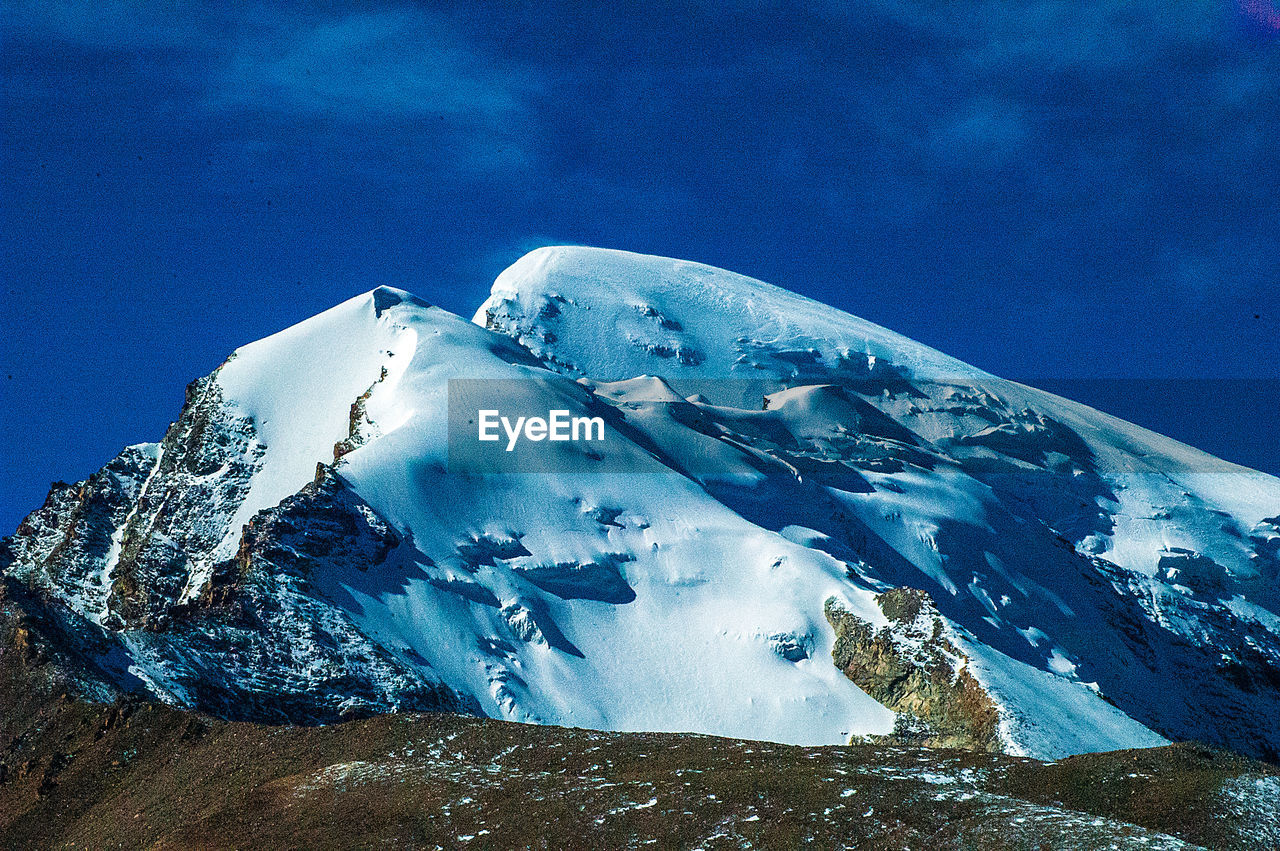 SNOWCAPPED MOUNTAINS AGAINST BLUE SKY