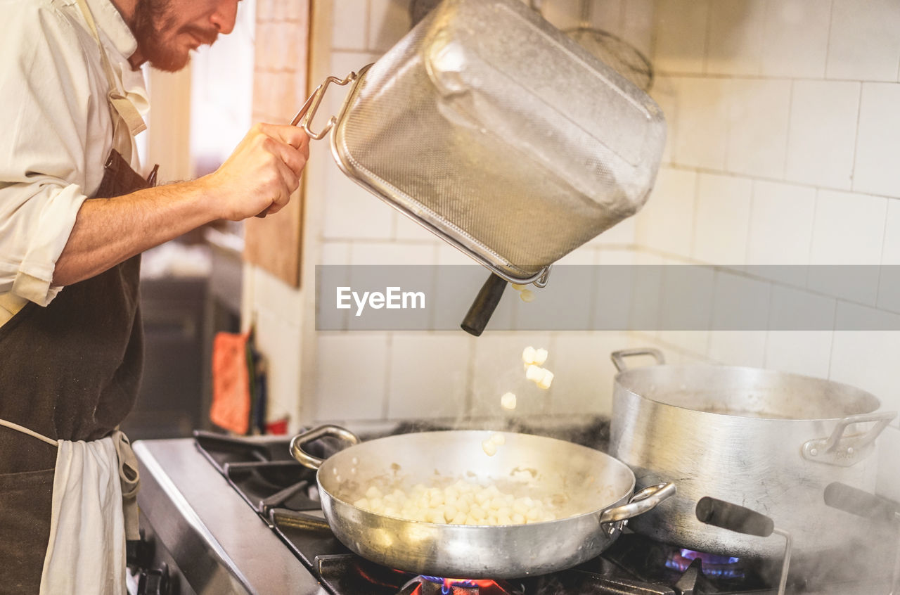 Midsection of mature chef working in kitchen