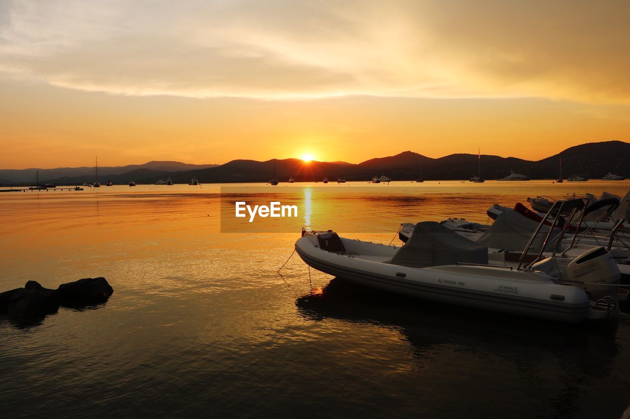 Boat in sea against sky during sunset