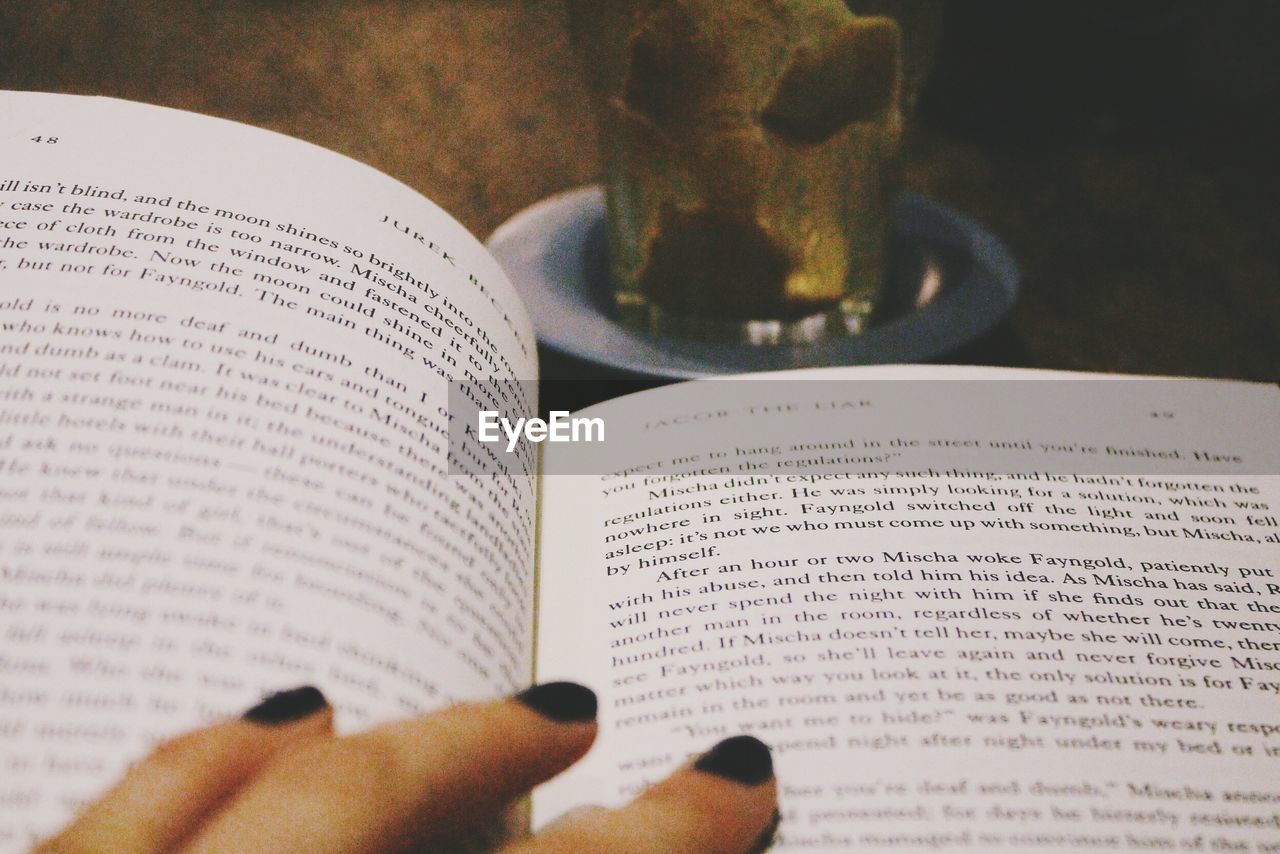 Close-up of hand on book at table