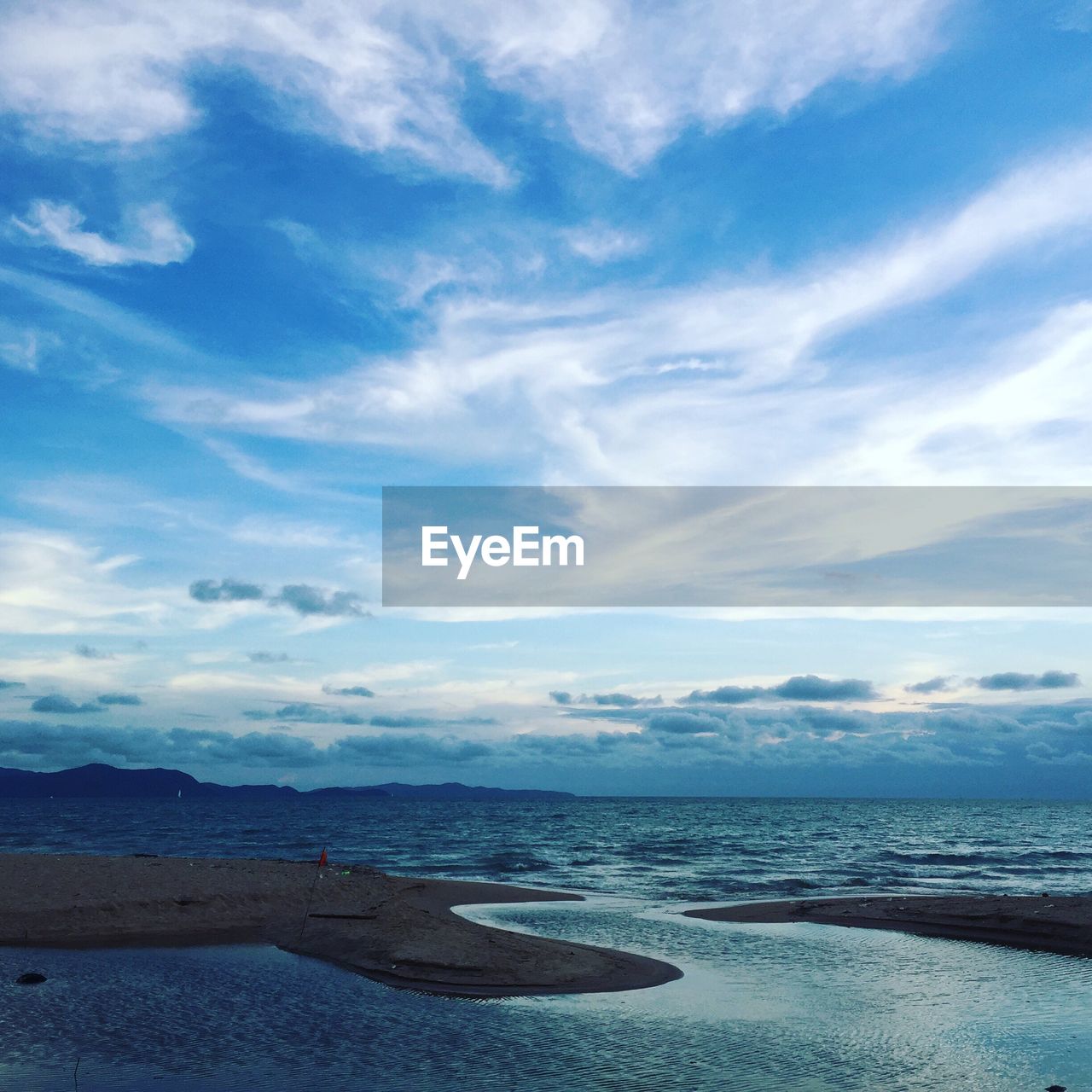 Scenic view of calm sea against cloudy sky