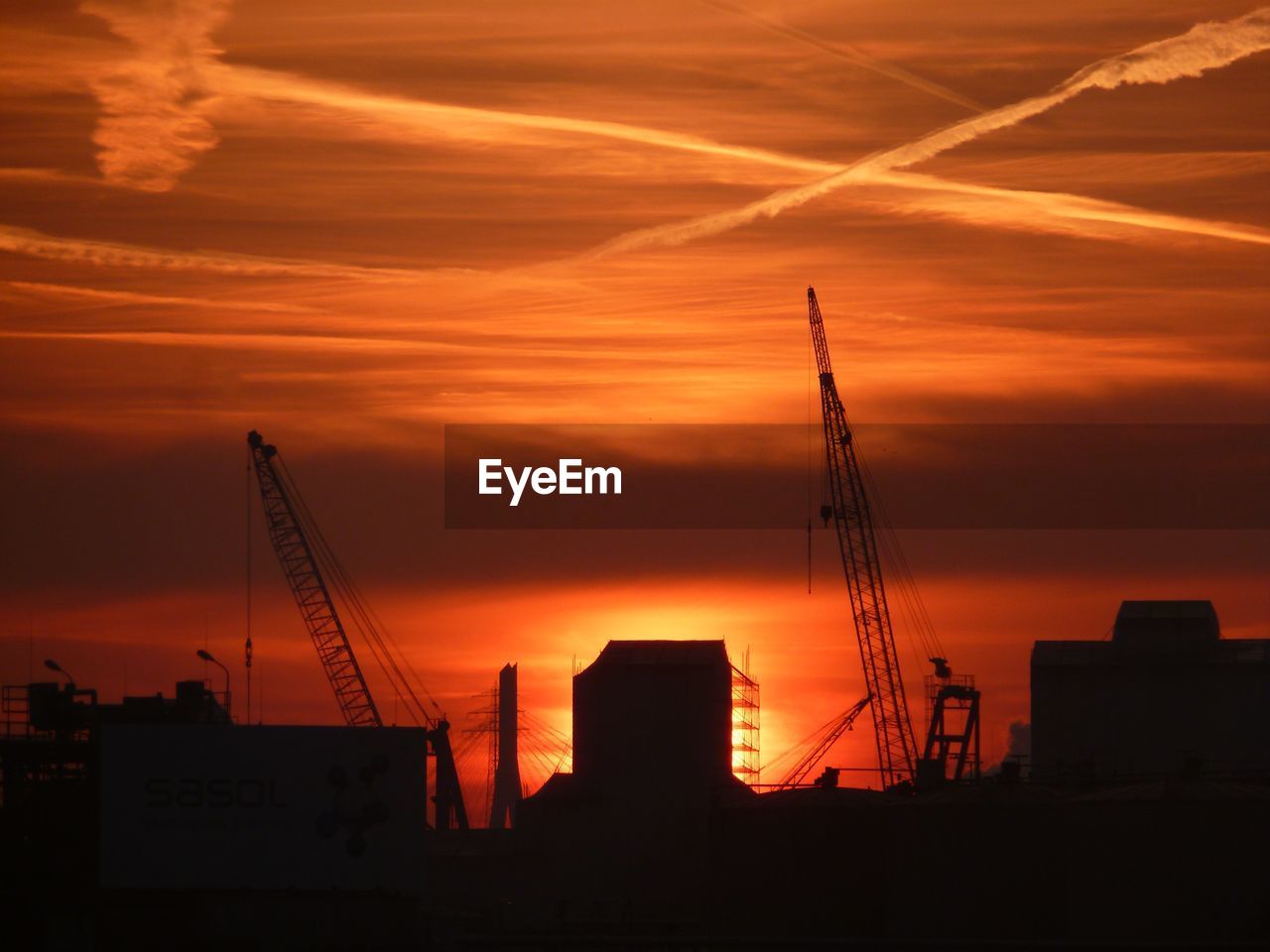 SILHOUETTE OF CITY AGAINST ORANGE SKY