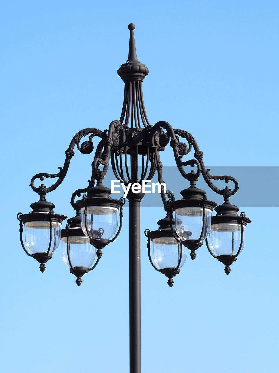 Low angle view of street light against clear blue sky on sunny day