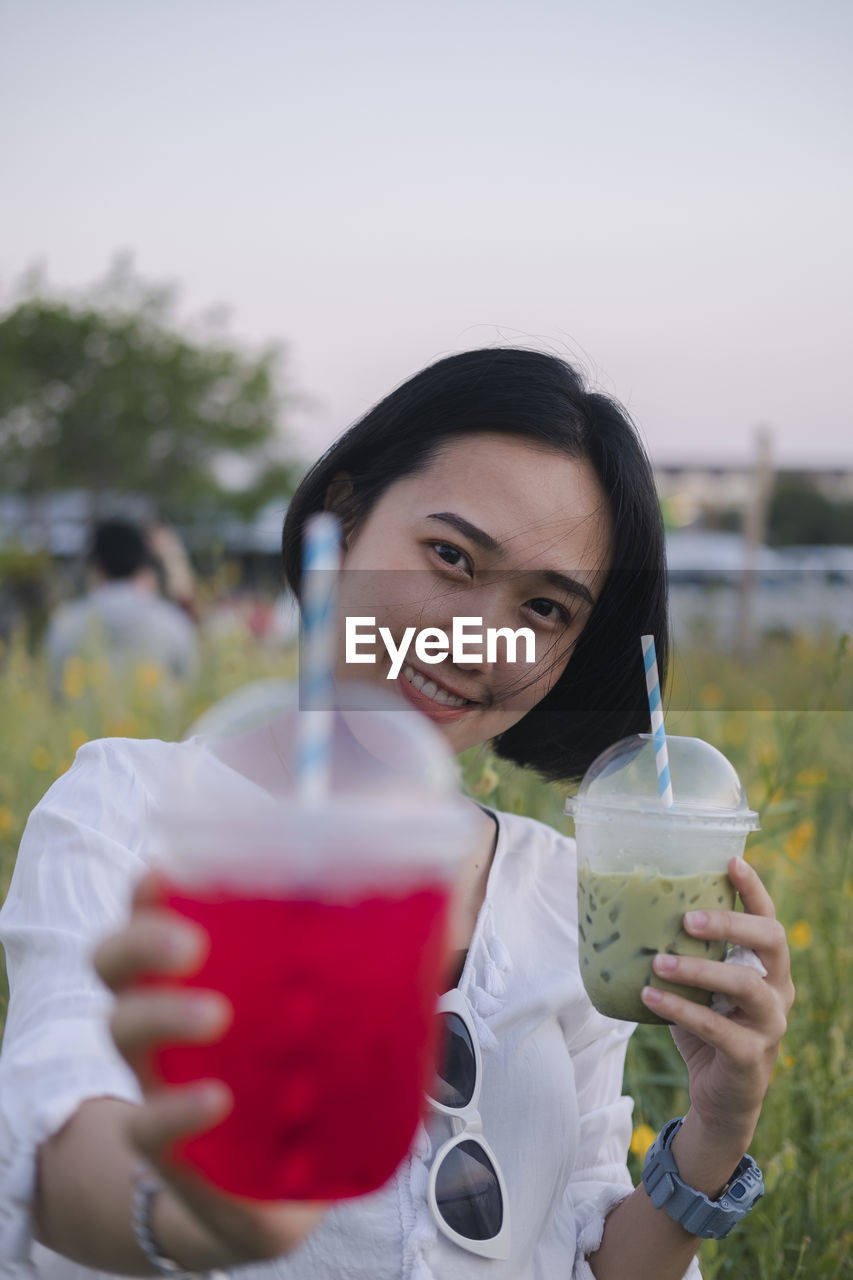 Portrait of a young woman drinking glass