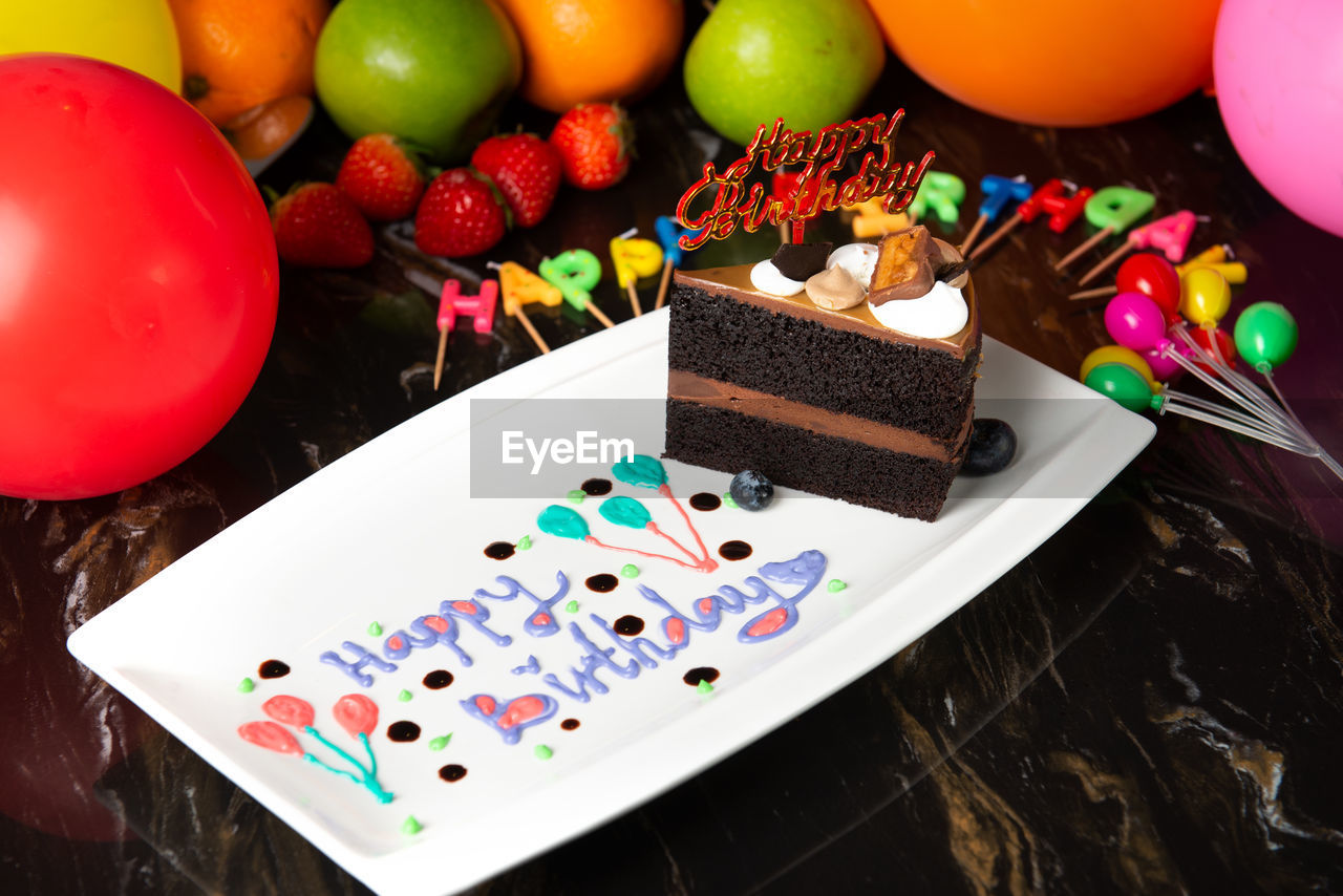 HIGH ANGLE VIEW OF MULTI COLORED CAKE ON TABLE