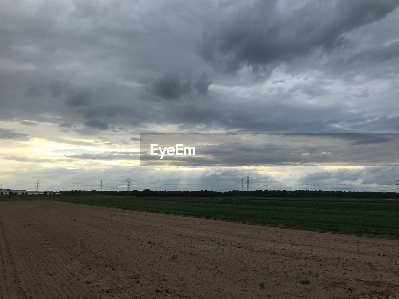 FIELD AGAINST CLOUDY SKY