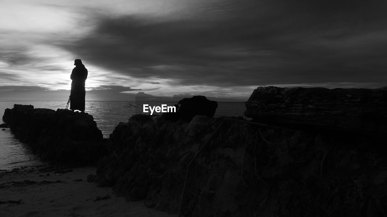 Rock formations on beach against sky