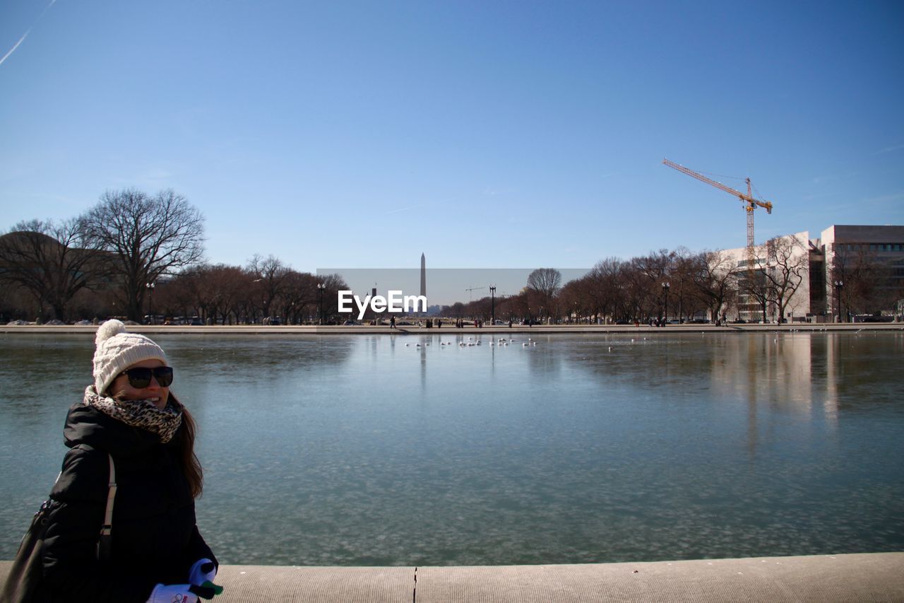 Portrait of woman standing against washington monument during sunny day