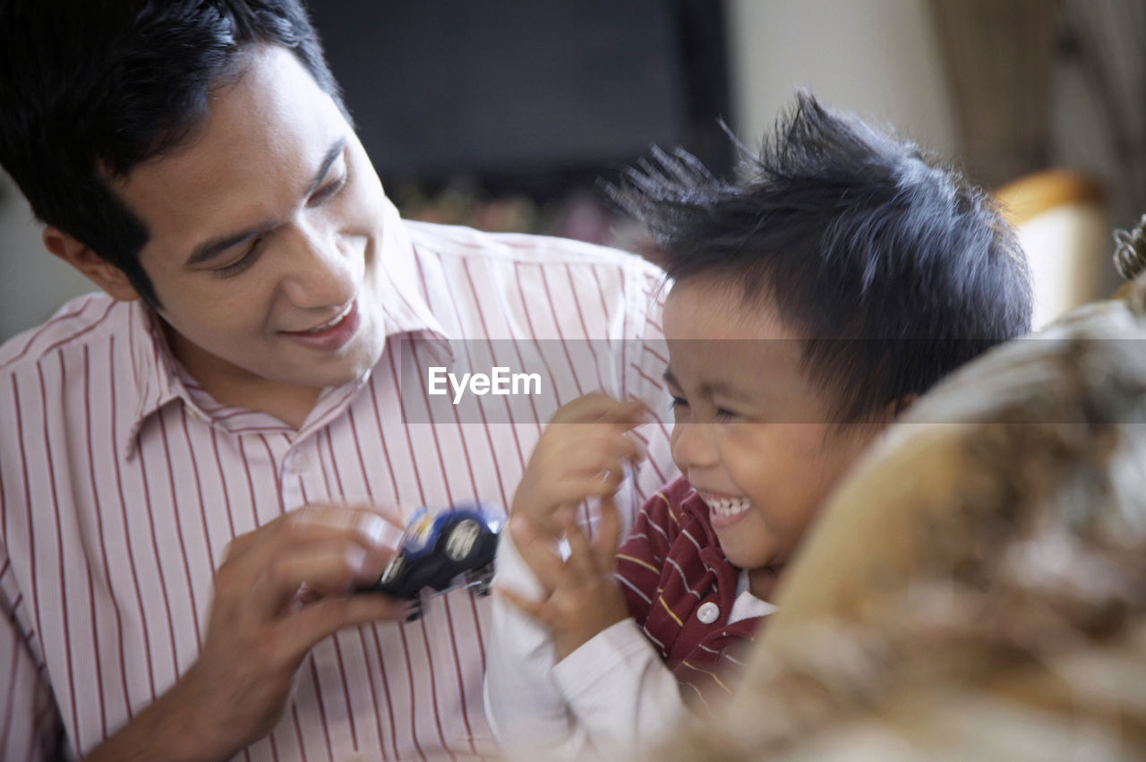 Father and son sitting on sofa at home