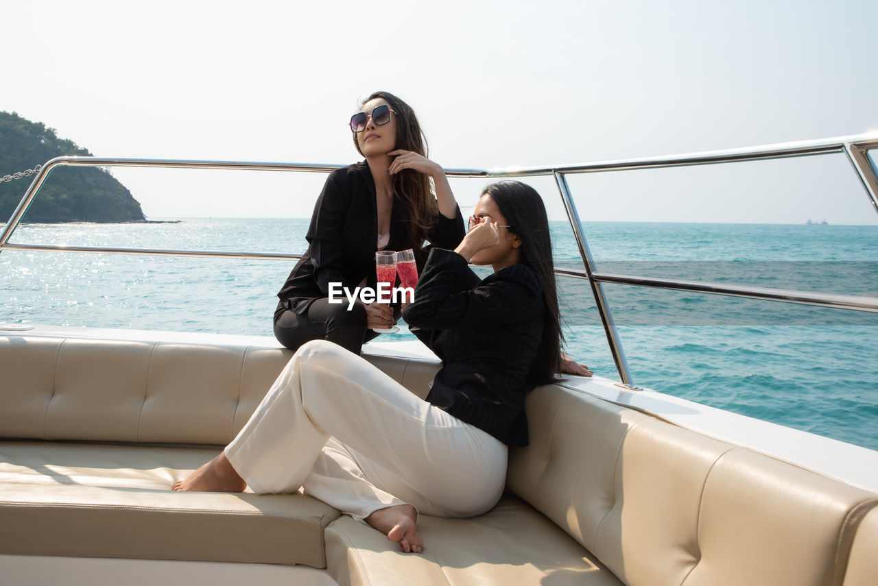 Woman sitting on boat in sea against sky