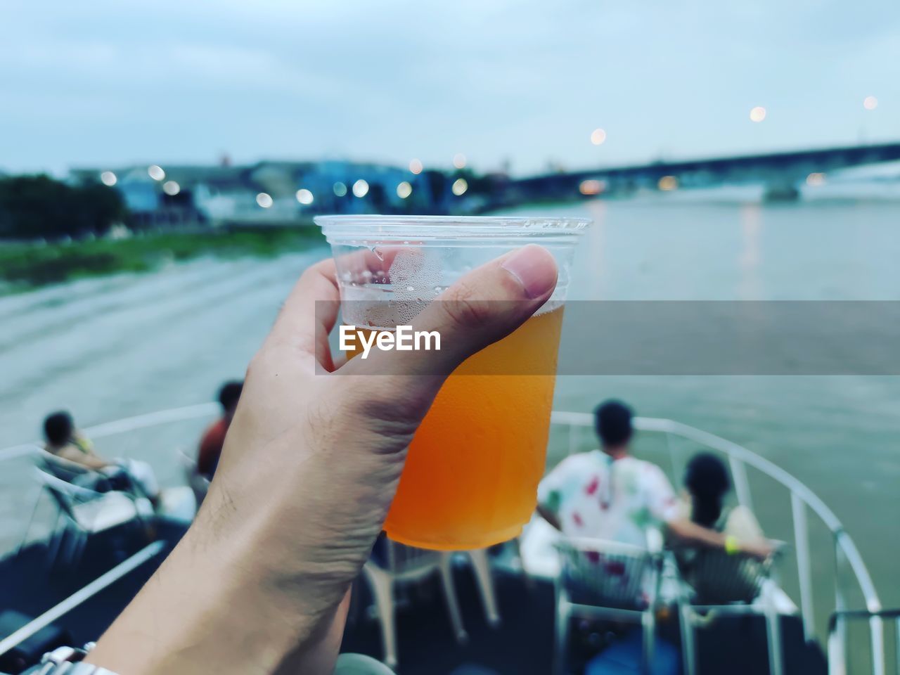 Cropped hand of man holding drink on boat