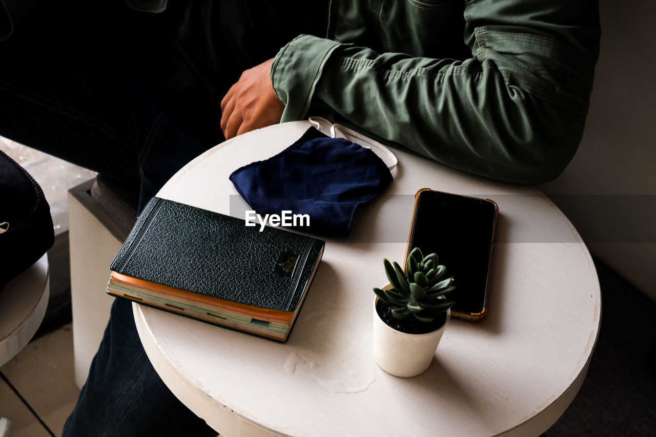 HIGH ANGLE VIEW OF MAN READING BOOK