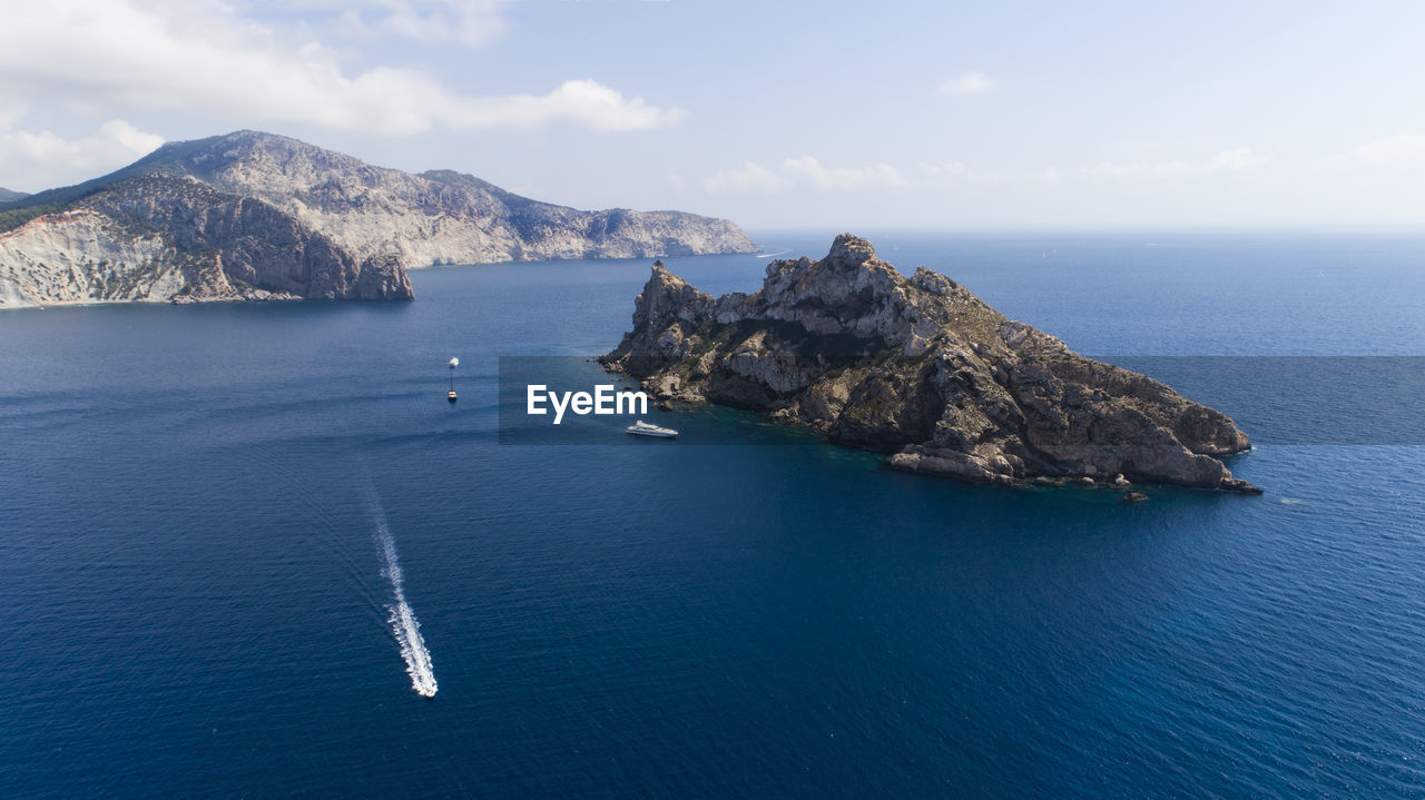 Scenic view of sea and mountains against sky