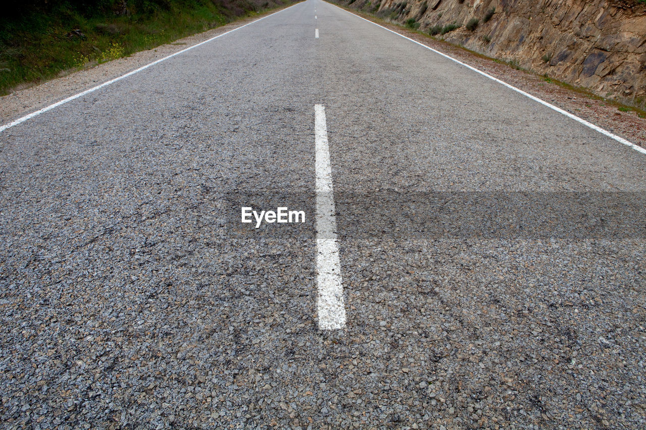 HIGH ANGLE VIEW OF ARROW SYMBOL ON ROAD MARKING