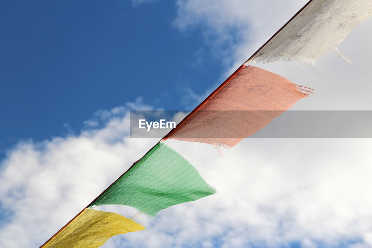 Low angle view of colorful flags against sky