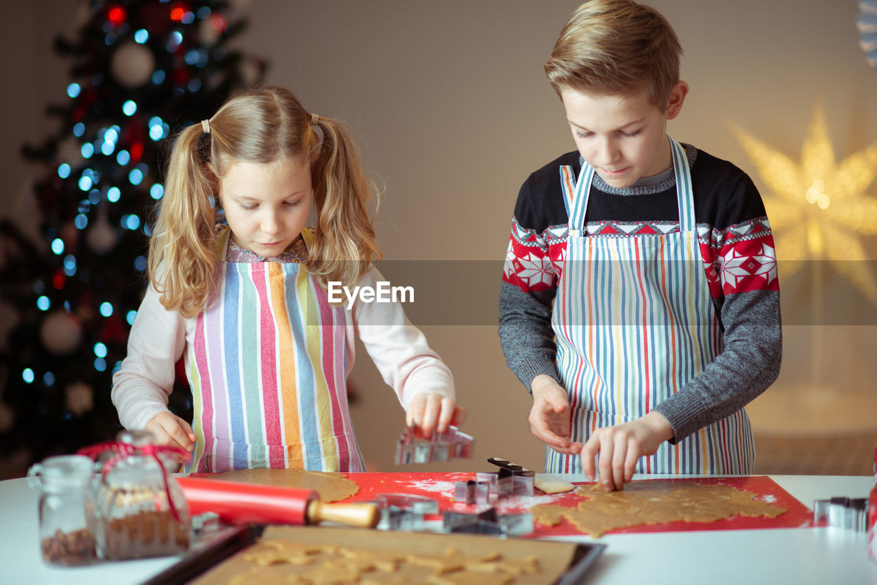 Siblings preparing cookies at home