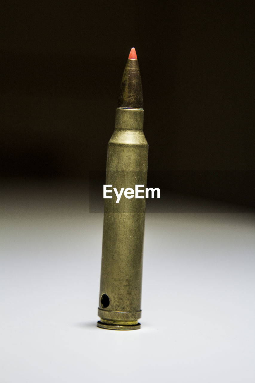 Close-up of pen on table against black background