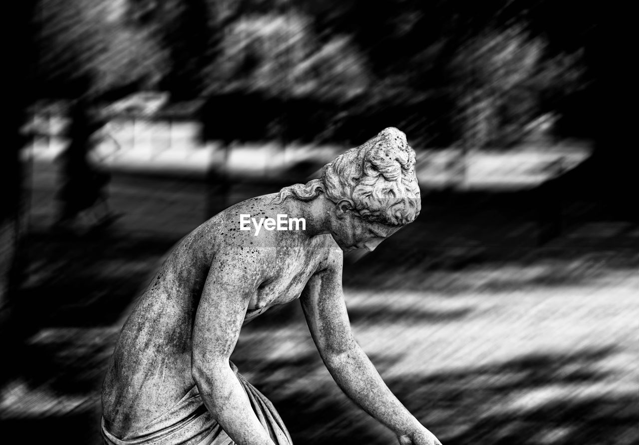 CLOSE-UP OF ANGEL STATUE AGAINST BLURRED BACKGROUND