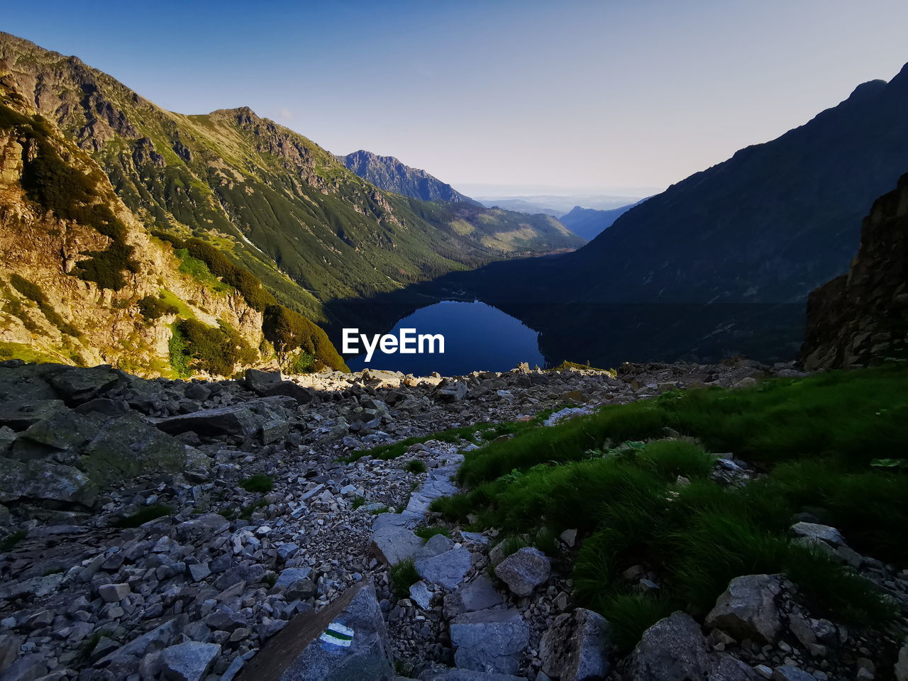 Scenic view of lake by mountains against sky