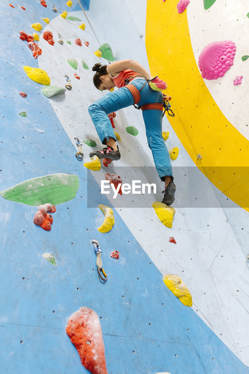 Low angle view of woman climbing on wall