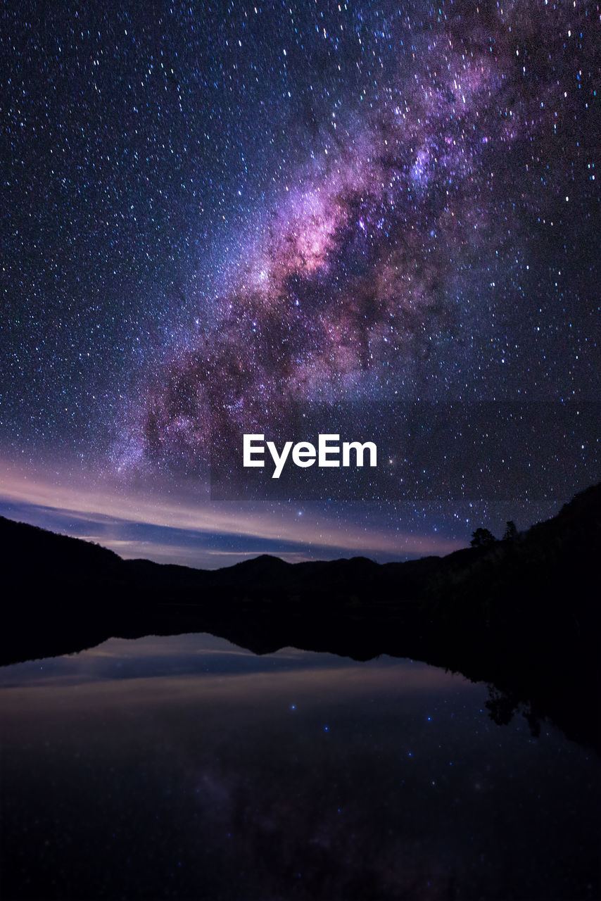 Scenic view of calm lake against star field