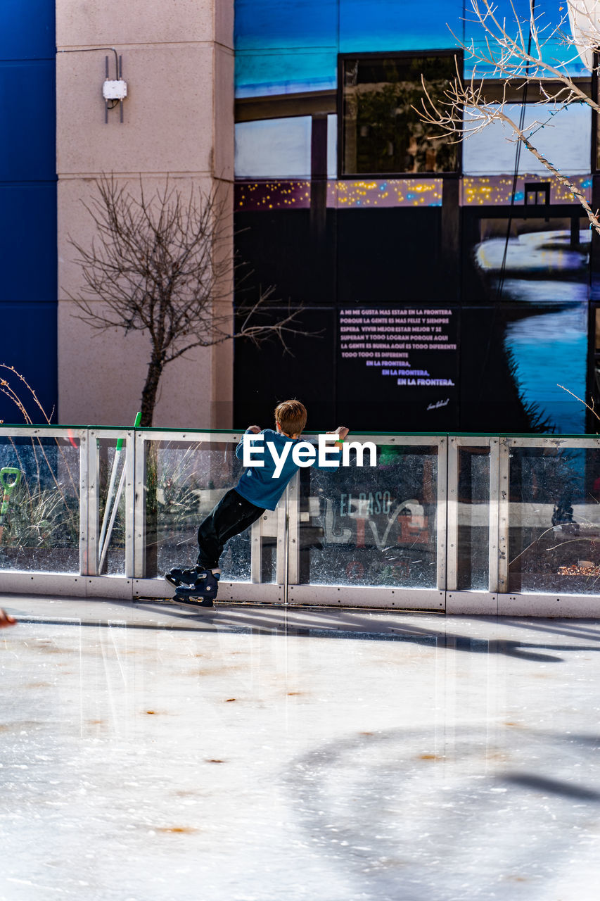 MAN JUMPING IN CITY AGAINST BUILDINGS IN WINTER