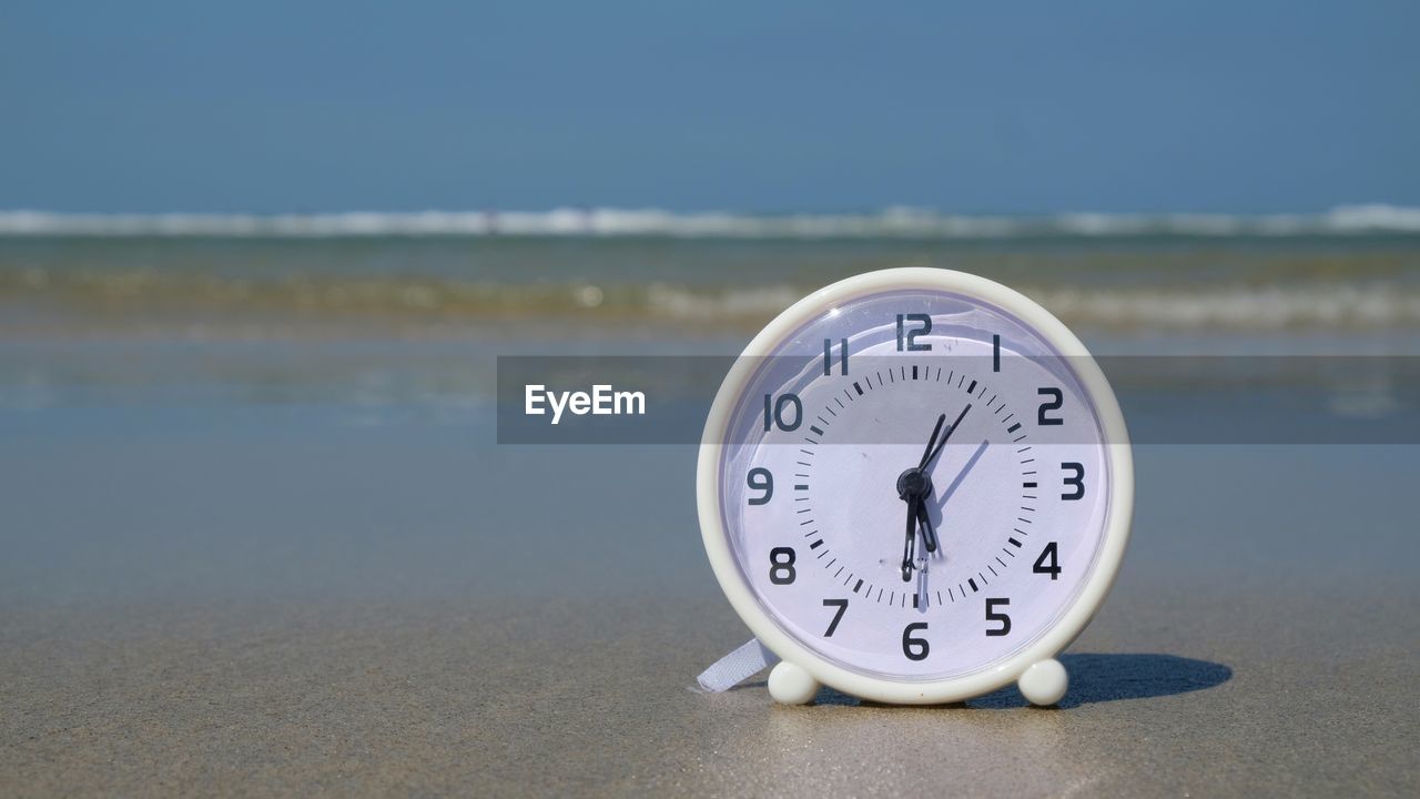 Close-up of clock on the beach