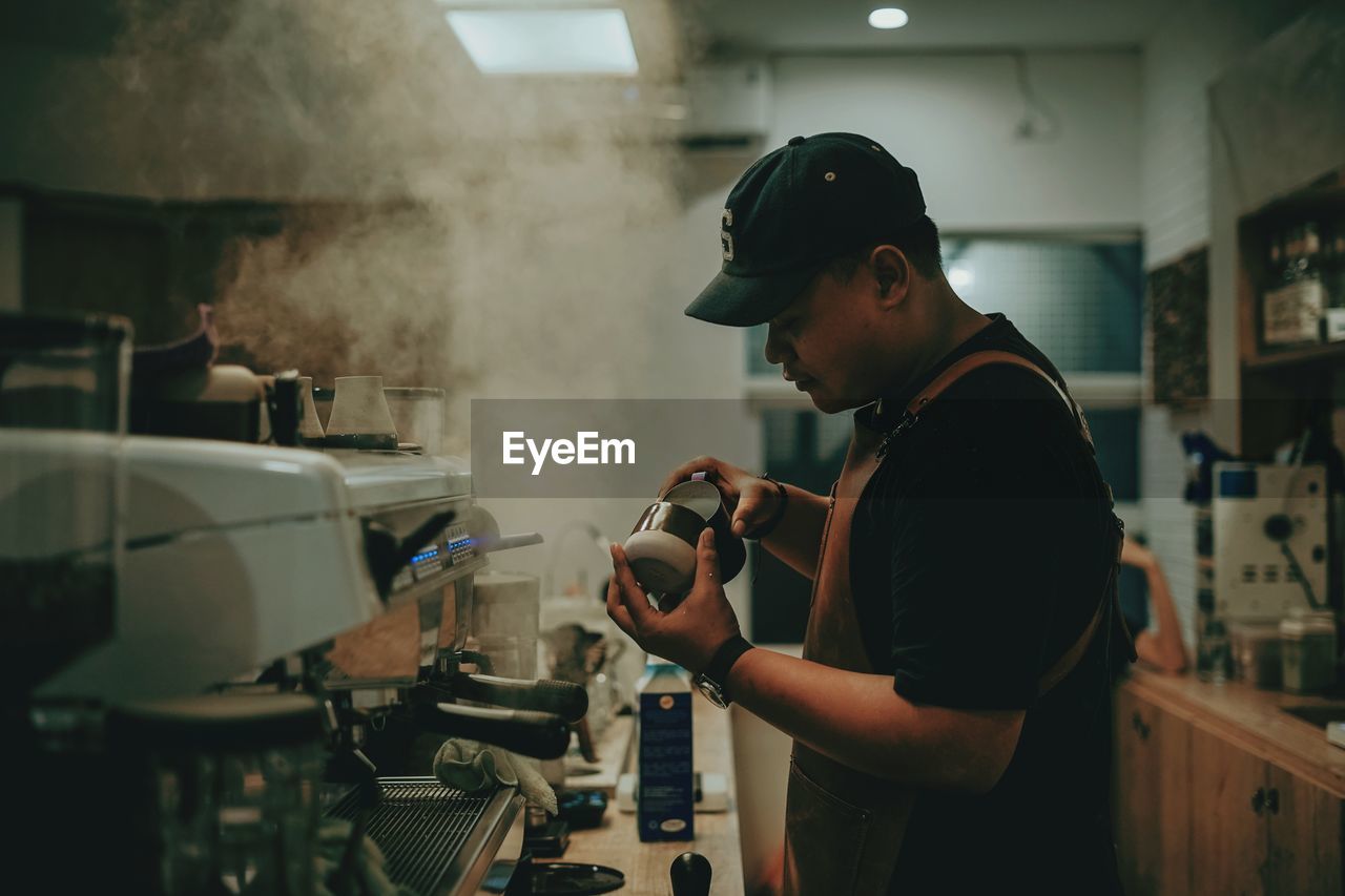 SIDE VIEW OF A MAN WORKING IN OFFICE