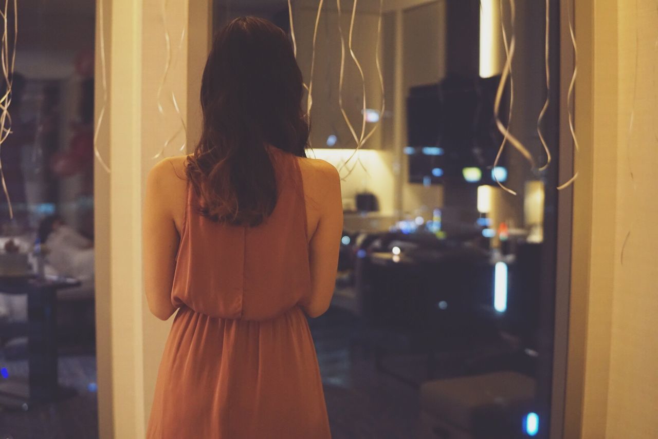 Rear view of woman in room with streamers