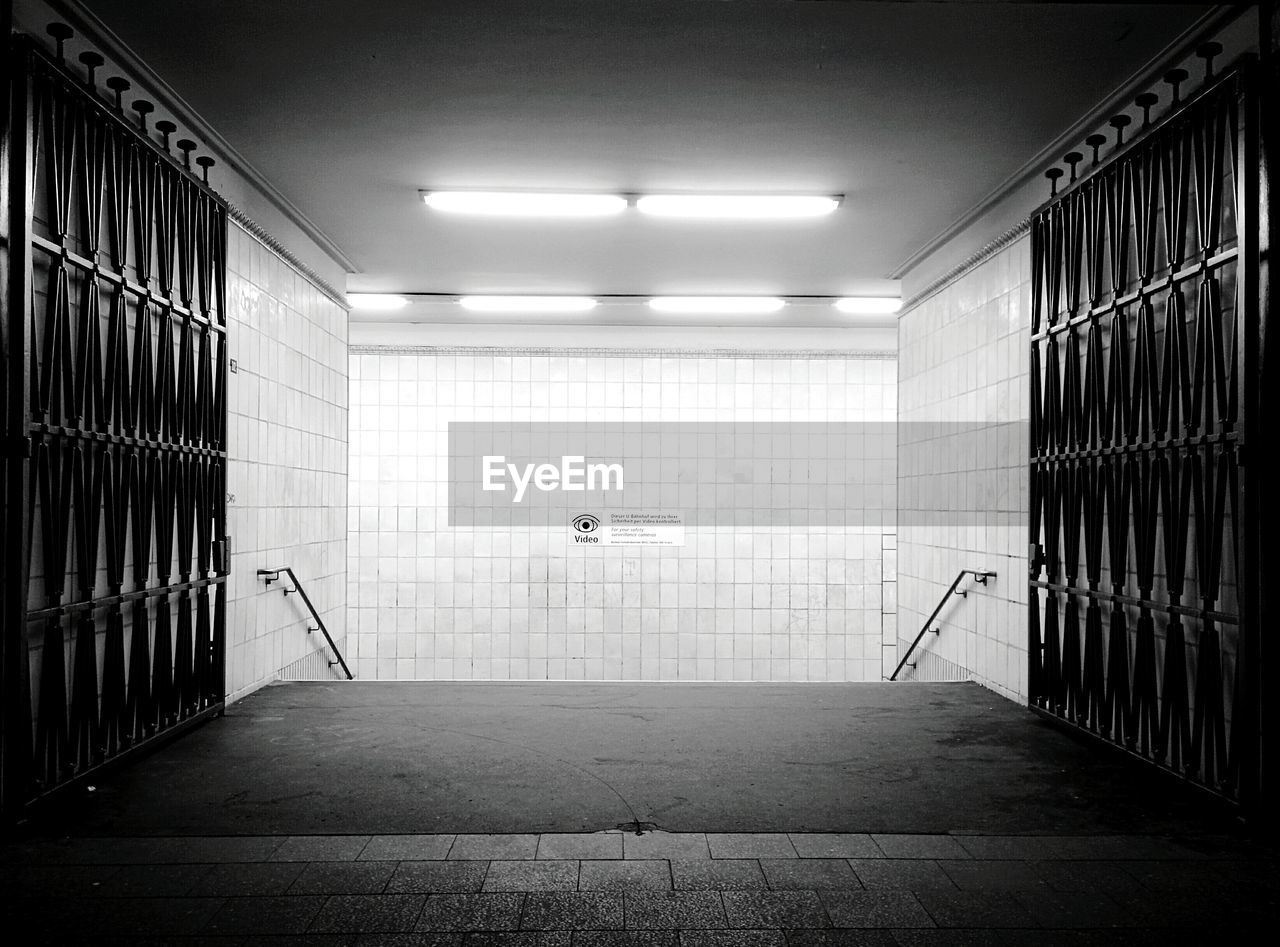 Open gates along tiled walls in subway