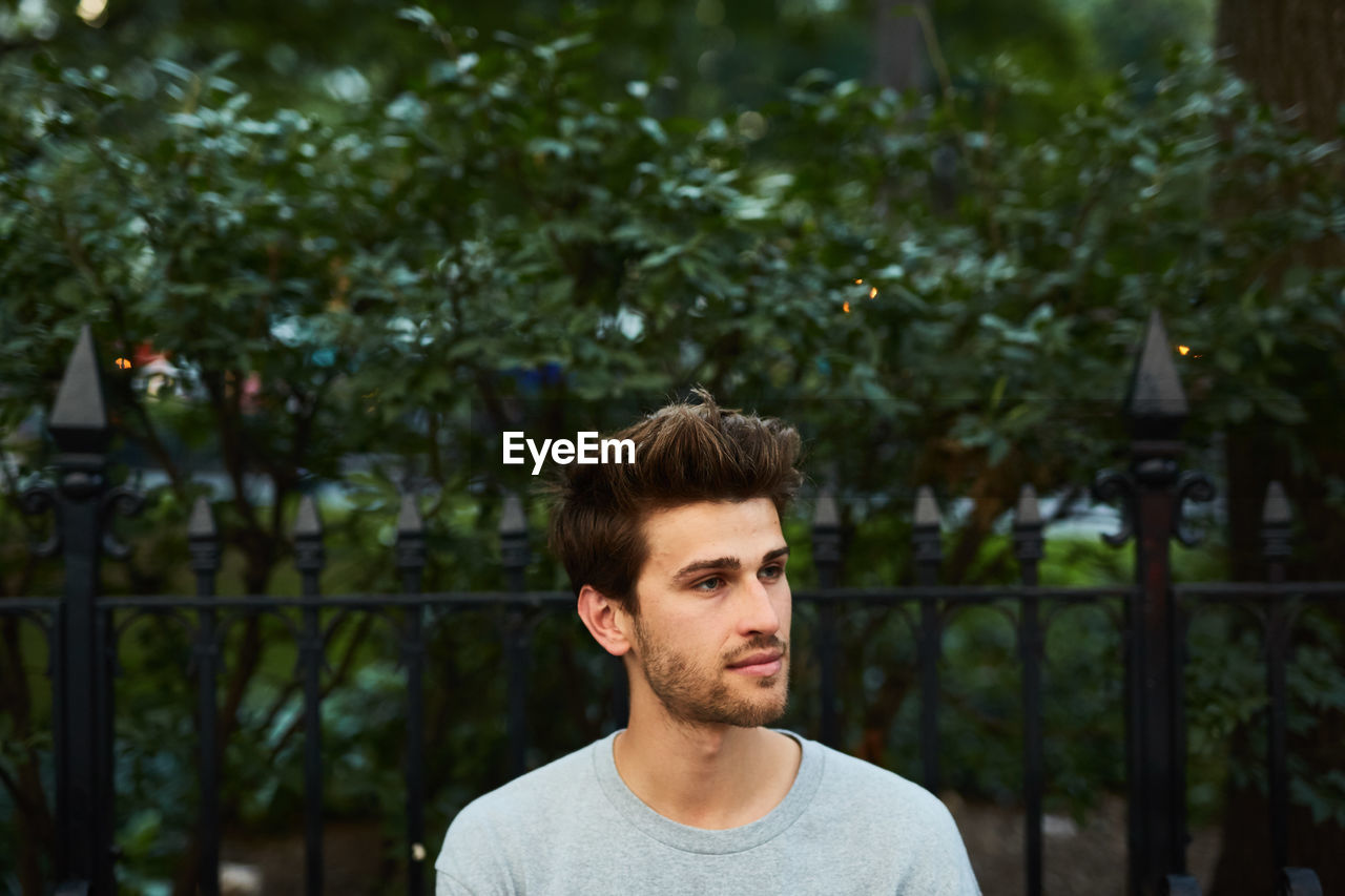 Young man against trees