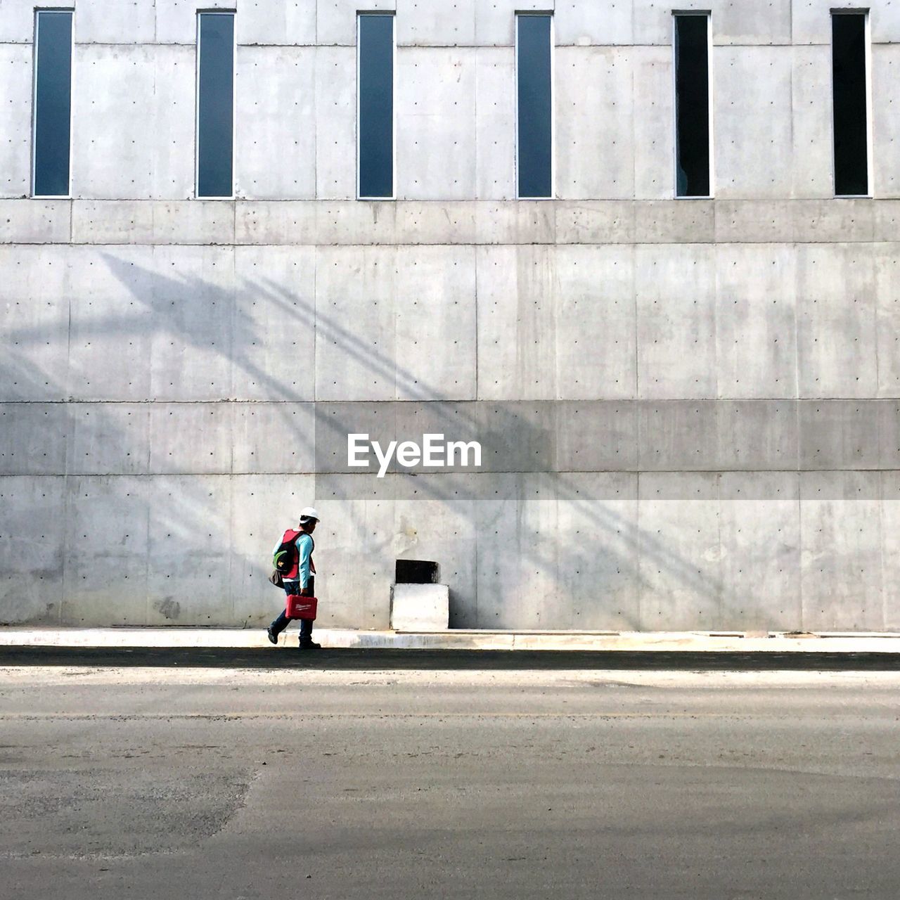 Rear view of man walking on footpath