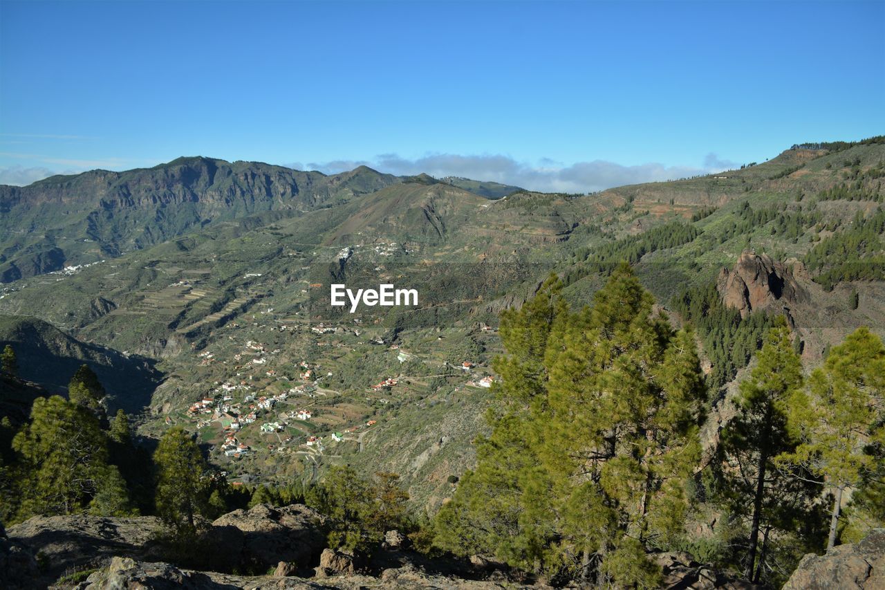 Scenic view of mountains against blue sky