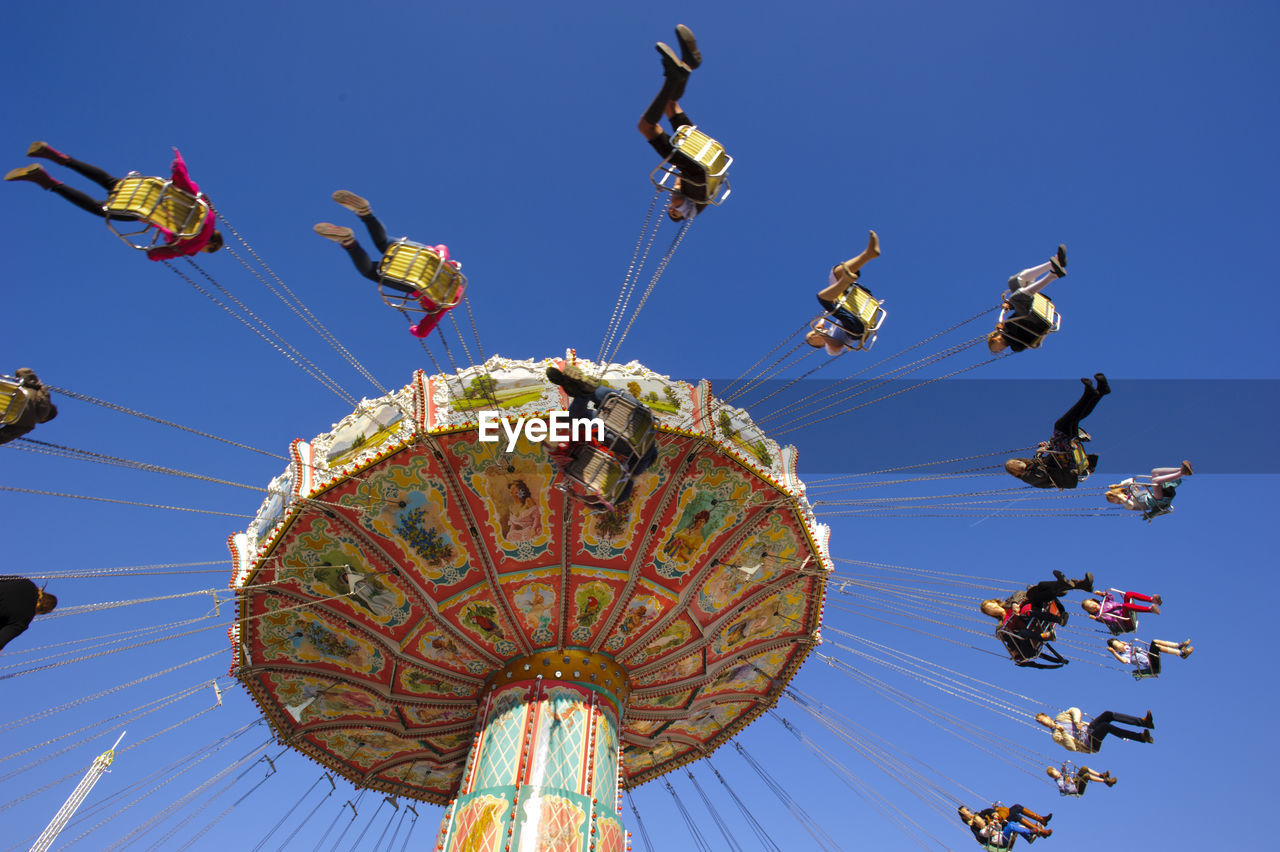 LOW ANGLE VIEW OF CHAIN SWING RIDE AGAINST CLEAR SKY