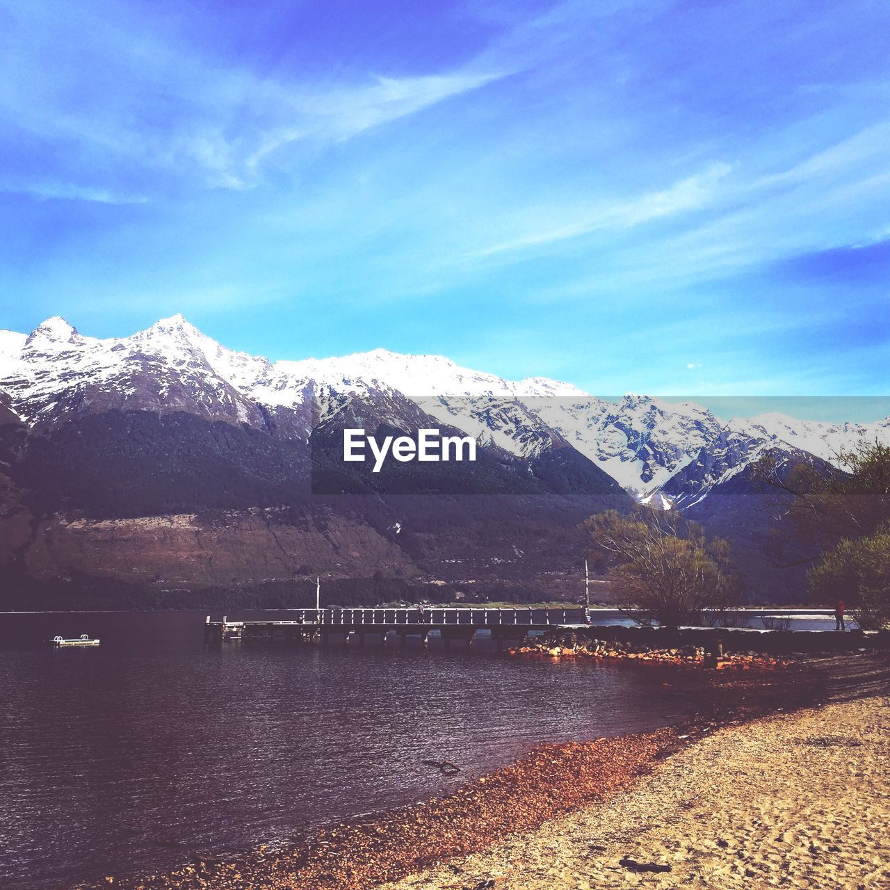 SCENIC VIEW OF LAKE BY MOUNTAINS AGAINST BLUE SKY