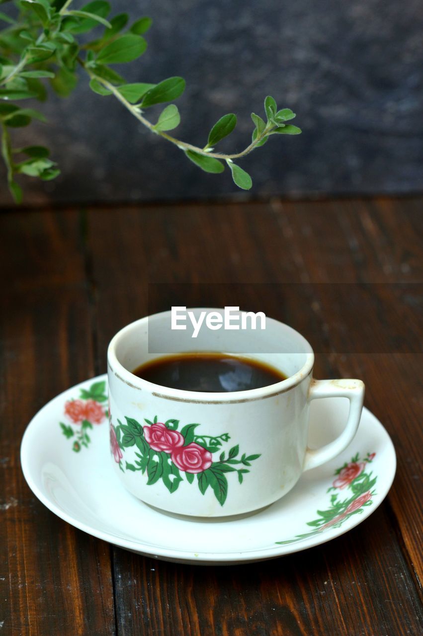 TEA CUP OF COFFEE ON TABLE